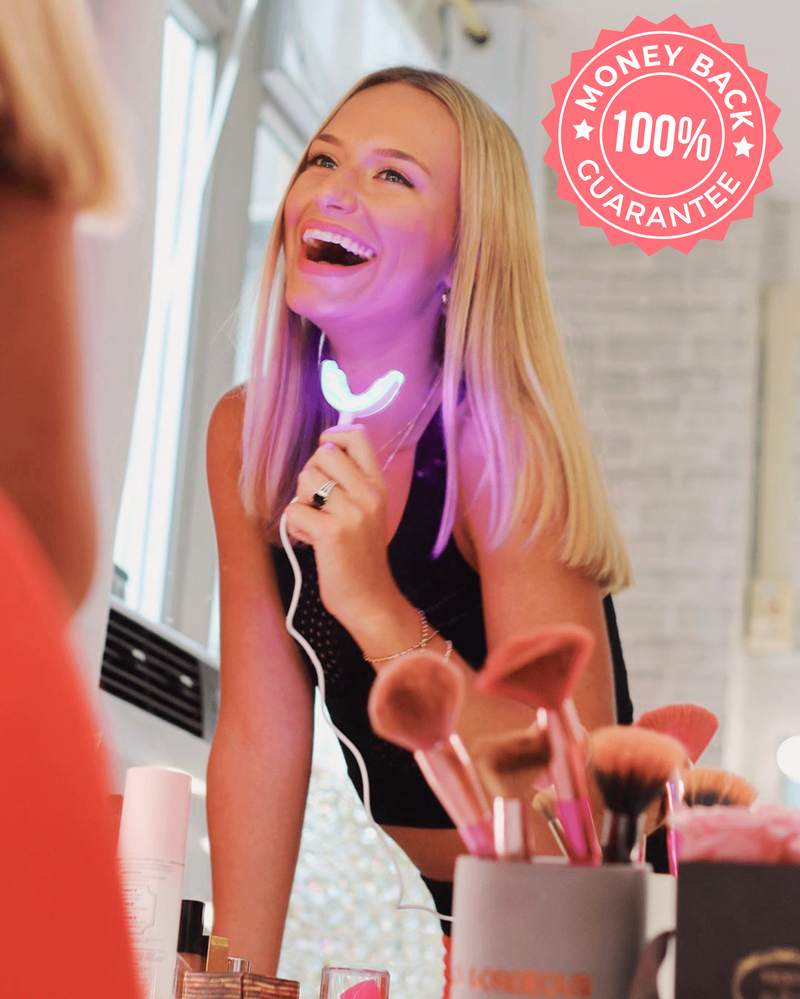 Woman smiling with the Teeth Whitening LED mouthpiece